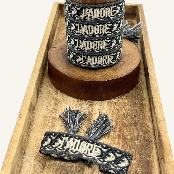 Bracciale in tessuto ricamato bianco e nero con scritta "J'ADORE"