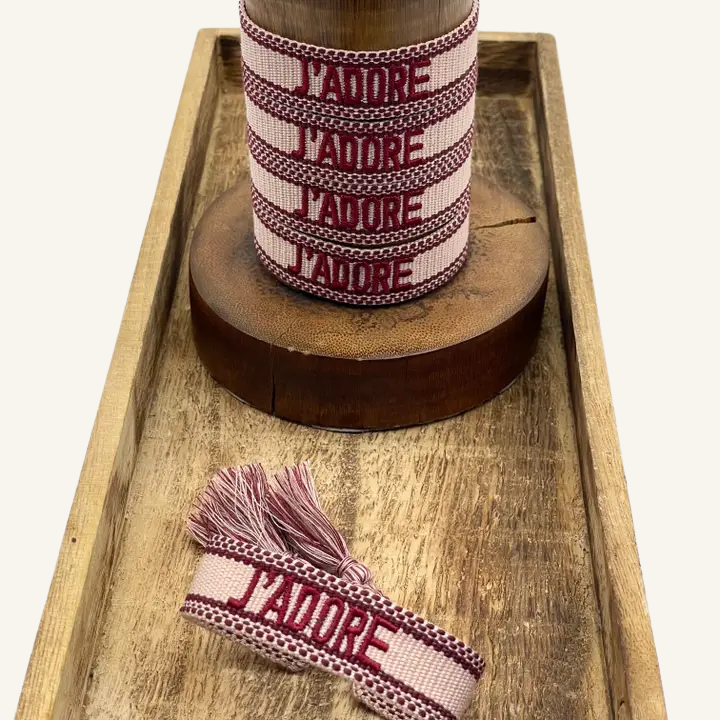 Bracciale in tessuto ricamato rosso e rosa con scritta "J'ADORE"