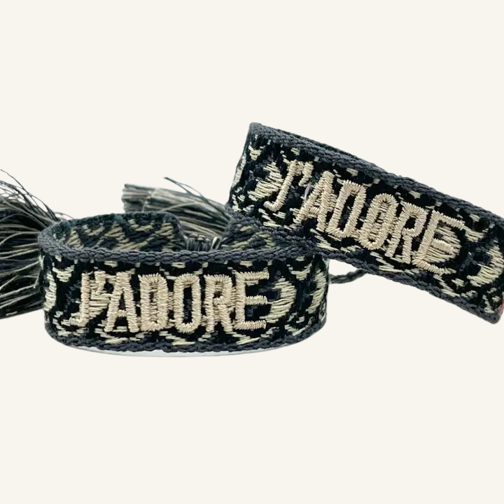 Bracciale in tessuto ricamato bianco e nero con scritta "J'ADORE"