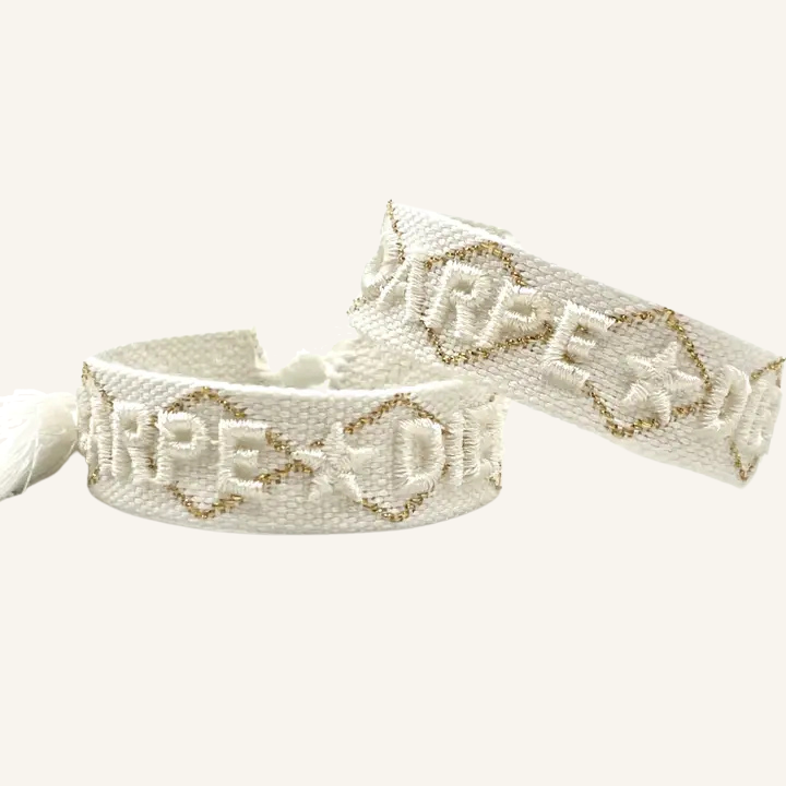 Bracciale in tessuto ricamato bianco e oro con scritta "CARPE DIEM"
