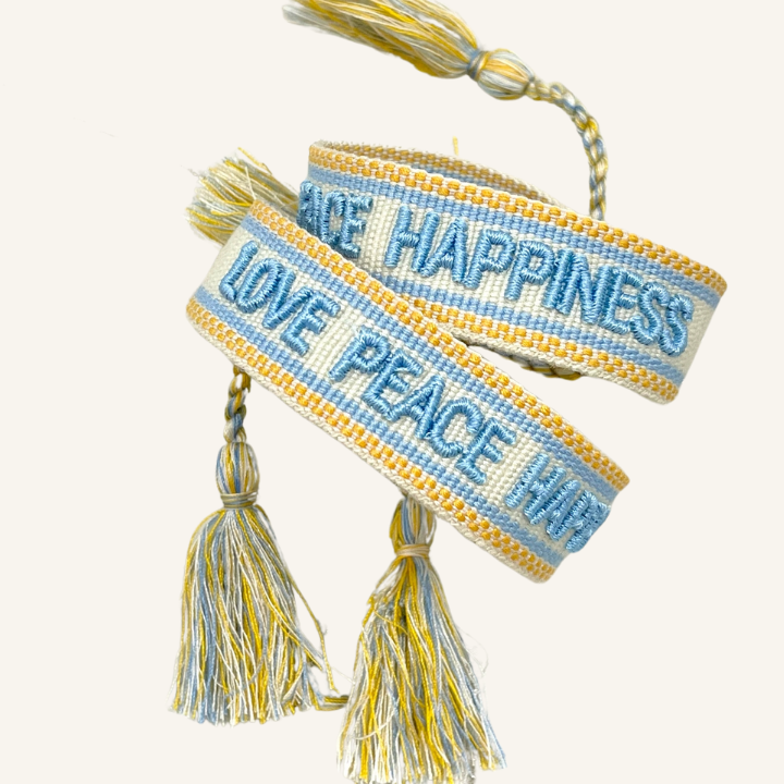 Bracciale in tessuto ricamato bianco, azzurro e arancione con scritta "LOVE PEACE HAPPINESS"