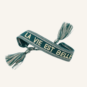 Bracciale in tessuto ricamato blu petrolio con scritta bianca "LA VIE EST BELLE"